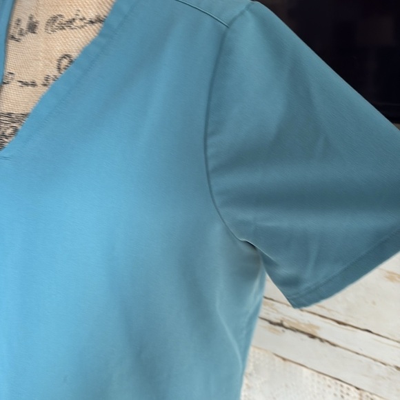 FIGS v-neck short sleeve two front pocket scrub shirt in a blue green color - Picture 4 of 16